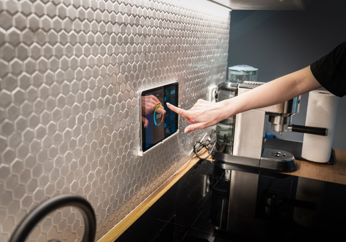 A wall-mounted smart climate panel showing the room temperature